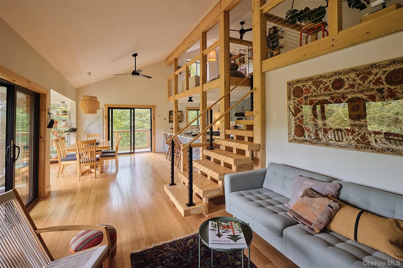 Open living room with vaulted ceilings, sofa and stairs to the loft